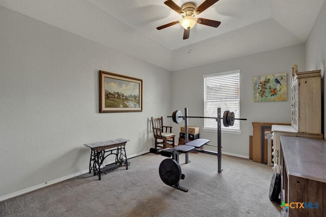 workout room with a raised ceiling, light carpet, and ceiling fan