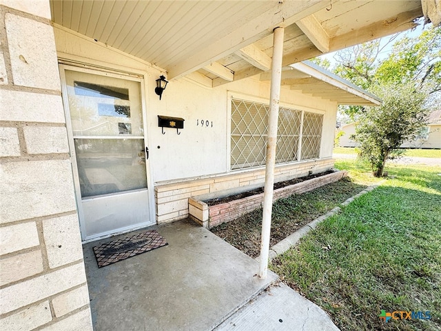 doorway to property featuring a lawn