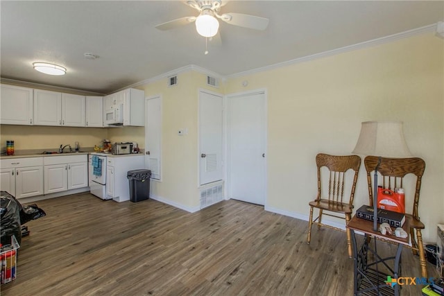 kitchen featuring range, hardwood / wood-style flooring, white cabinetry, and ornamental molding