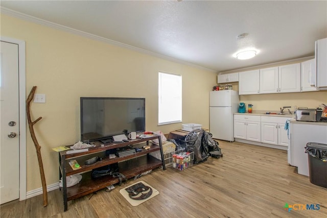 kitchen featuring crown molding, sink, white refrigerator, light hardwood / wood-style flooring, and white cabinetry