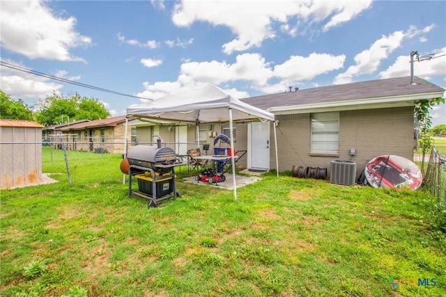 rear view of house with a yard and central AC unit