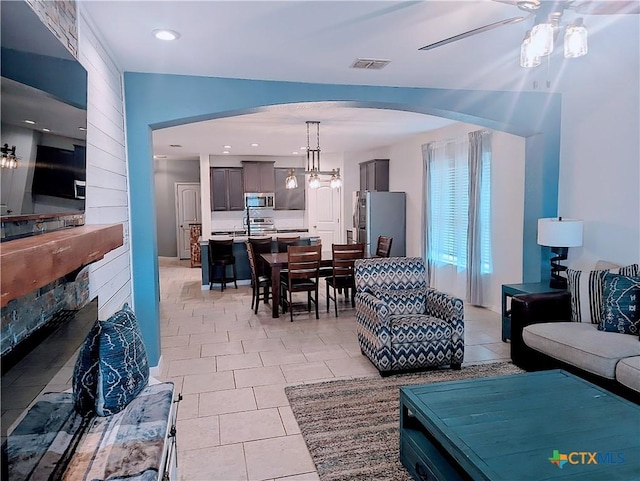 tiled living room featuring ceiling fan