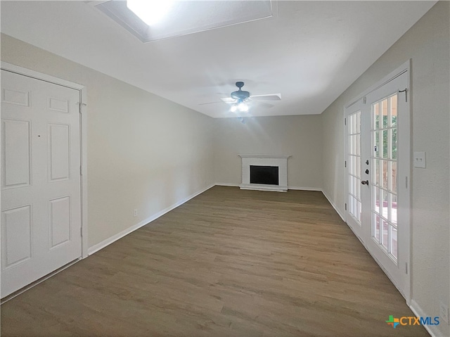 unfurnished living room with wood-type flooring, ceiling fan, and french doors