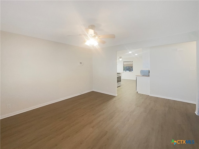 unfurnished room featuring dark wood-type flooring and ceiling fan