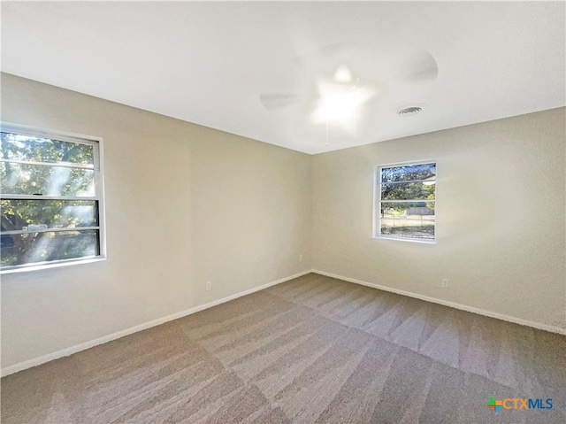 carpeted spare room featuring ceiling fan