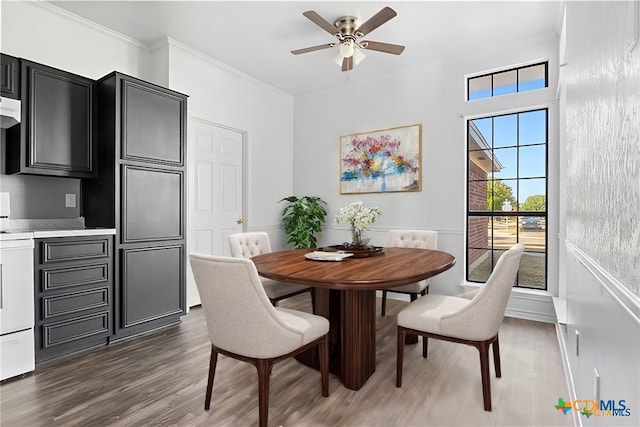 dining room with ceiling fan, crown molding, and dark wood-type flooring