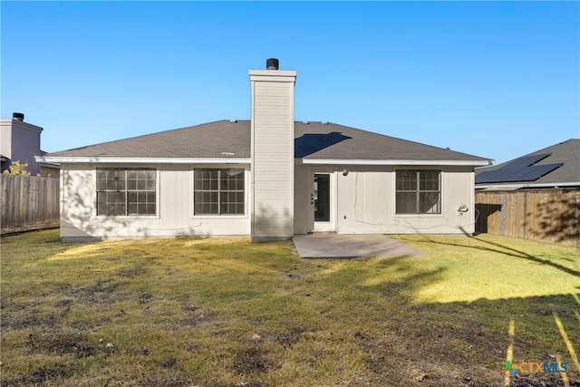 back of property with a lawn and a patio area