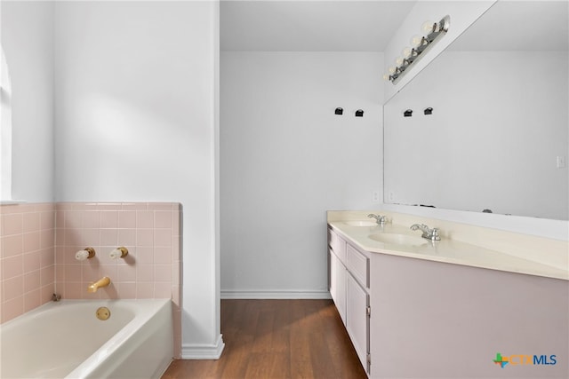 bathroom with a washtub, vanity, and hardwood / wood-style flooring