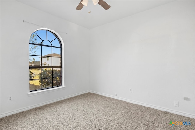 carpeted spare room featuring ceiling fan