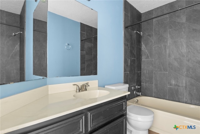 full bathroom with vanity, toilet, a textured ceiling, and tiled shower / bath