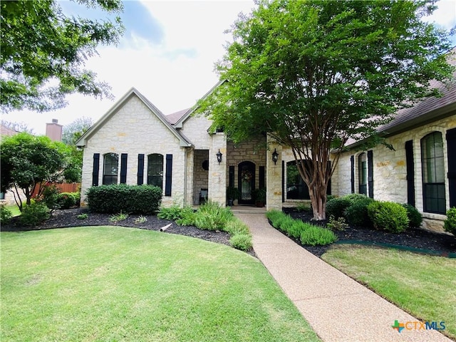 view of front of home featuring a front yard and stone siding