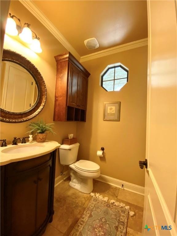 bathroom with baseboards, toilet, crown molding, and vanity