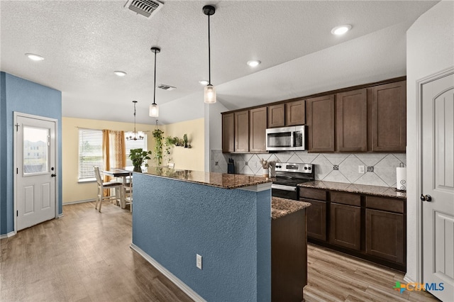 6505 Cassidy Ln, Killeen, TX 76542 - kitchen featuring appliances with stainless steel finishes, light wood-style floors, tasteful backsplash, dark brown cabinetry, and dark stone countertops