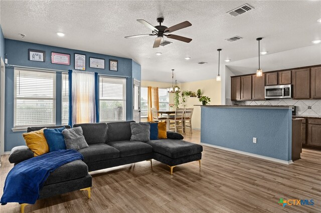 6505 Cassidy Ln, Killeen, TX 76542 - living room featuring light wood-type flooring, a ceiling fan, a textured ceiling, a chandelier, and recessed lighting