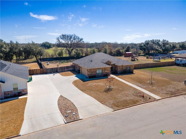 ranch-style house with driveway and fence