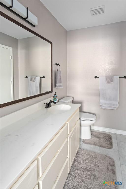 bathroom with tile patterned flooring, vanity, and toilet