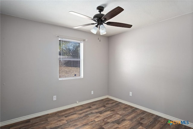 spare room with dark hardwood / wood-style floors and ceiling fan