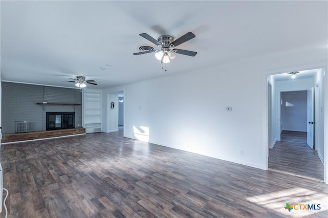 unfurnished living room with ceiling fan, dark hardwood / wood-style floors, and a brick fireplace