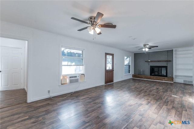 unfurnished living room with cooling unit, dark hardwood / wood-style floors, ceiling fan, ornamental molding, and a fireplace