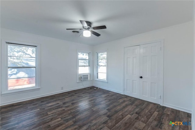 unfurnished bedroom featuring ceiling fan, a closet, dark wood-type flooring, and multiple windows