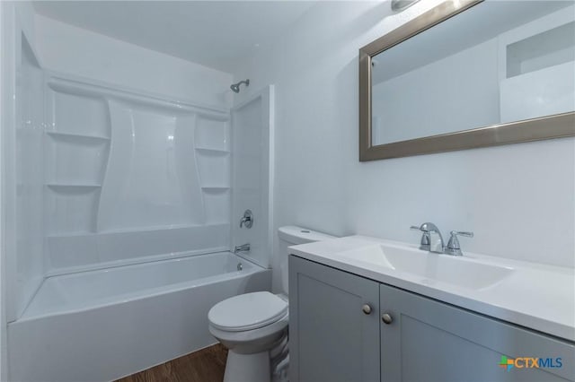 full bathroom featuring hardwood / wood-style floors, vanity, toilet, and washtub / shower combination