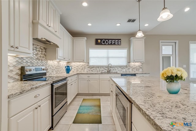 kitchen with light tile patterned floors, white cabinets, light stone countertops, stainless steel appliances, and a sink