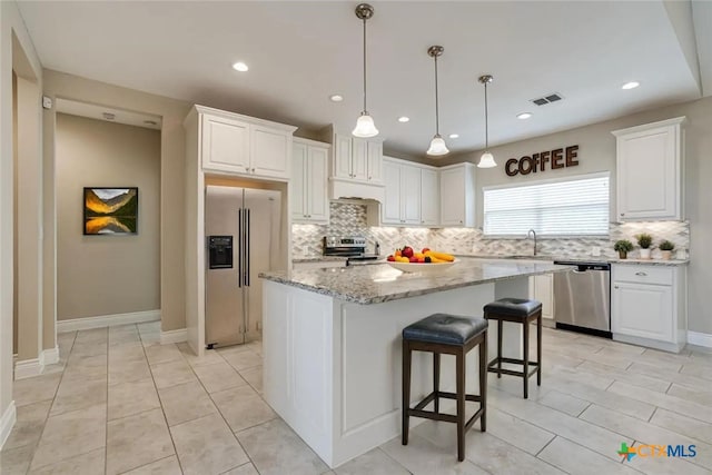 kitchen with appliances with stainless steel finishes, visible vents, a sink, and white cabinetry