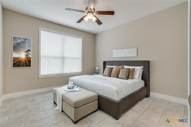 bedroom with light tile patterned floors, baseboards, and a ceiling fan