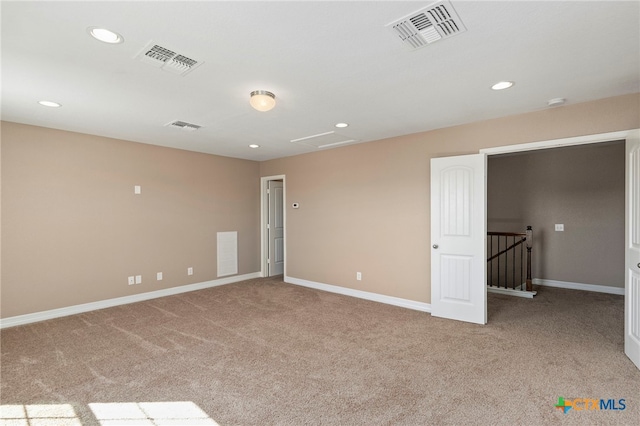 carpeted spare room featuring visible vents, recessed lighting, and baseboards