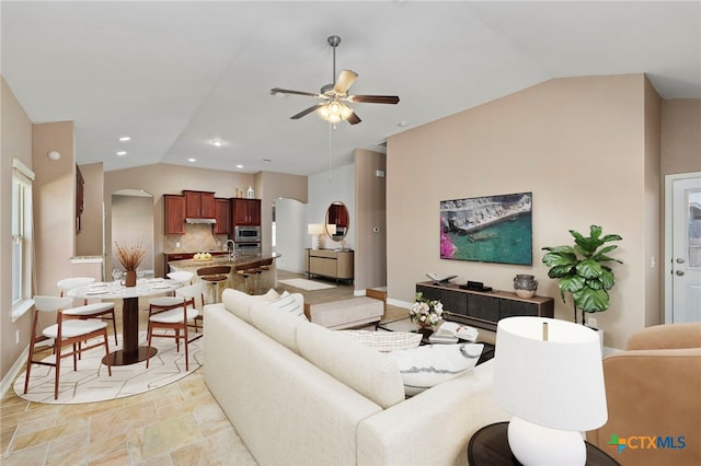 living area with a ceiling fan, baseboards, lofted ceiling, recessed lighting, and arched walkways