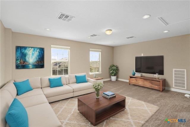 living area featuring visible vents, baseboards, and light colored carpet