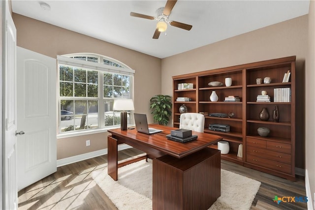 office space with a ceiling fan, baseboards, and wood finished floors