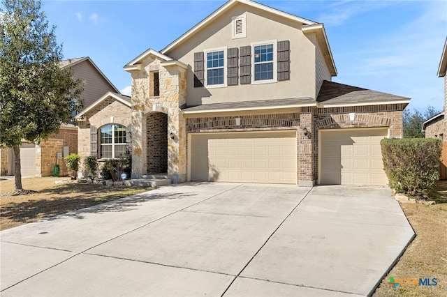 traditional-style home with concrete driveway, an attached garage, brick siding, and stucco siding