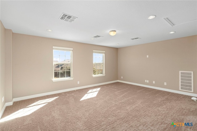 spare room featuring visible vents, baseboards, and carpet