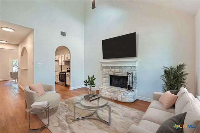 2033 Northview Dr, San Marcos, TX 78666 - living area with light wood finished floors, a fireplace, arched walkways, and a towering ceiling