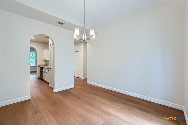 2033 Northview Dr, San Marcos, TX 78666 - unfurnished dining area with wood finished floors, arched walkways, and a chandelier