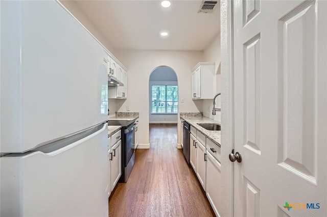 2033 Northview Dr, San Marcos, TX 78666 - kitchen with appliances with stainless steel finishes, dark wood-style floors, arched walkways, white cabinets, and recessed lighting
