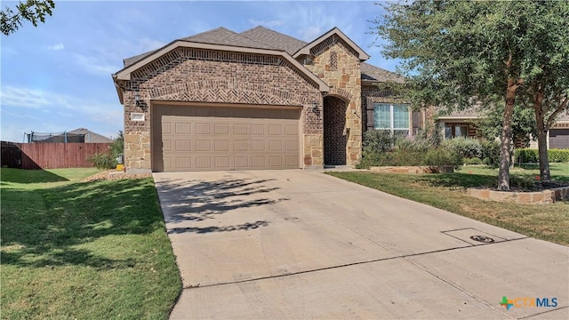 view of front facade featuring a front lawn, stone siding, fence, concrete driveway, and a garage