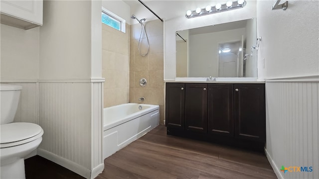 full bathroom featuring toilet, tiled shower / bath combo, vanity, and hardwood / wood-style flooring