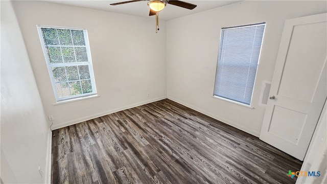 empty room with dark wood-type flooring, a wealth of natural light, and ceiling fan