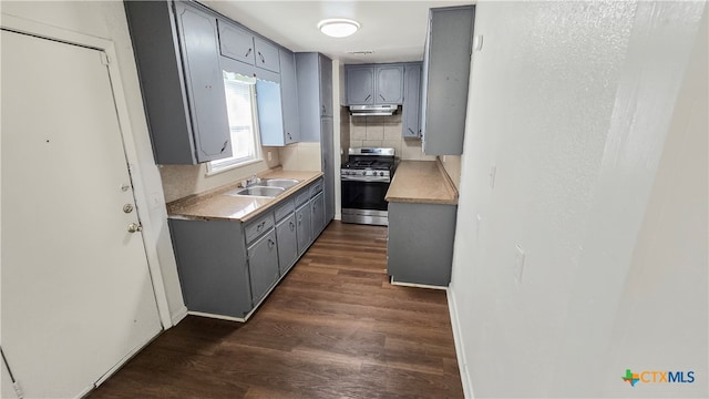 kitchen with tasteful backsplash, stainless steel gas stove, dark hardwood / wood-style floors, gray cabinets, and sink