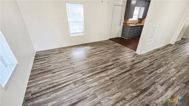 unfurnished living room featuring dark hardwood / wood-style floors and sink