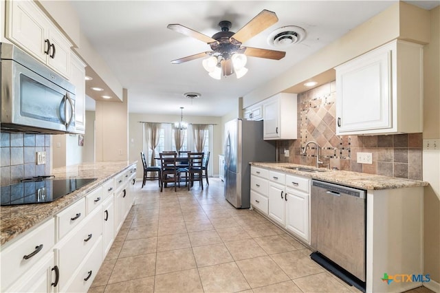 204 W Johnson St, Cuero, TX 77954 - kitchen with stainless steel appliances, decorative backsplash, white cabinets, and recessed lighting