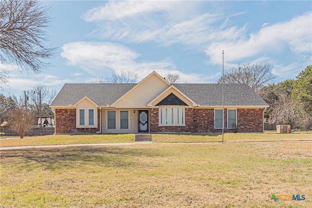 ranch-style home featuring roof with shingles, a front lawn, and brick siding