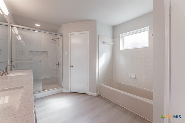 bathroom featuring double vanity, baseboards, combined bath / shower with glass door, and a sink