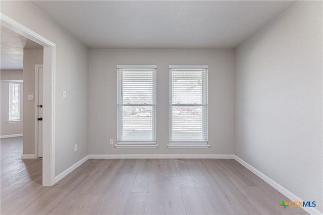 empty room featuring light wood-style flooring and baseboards