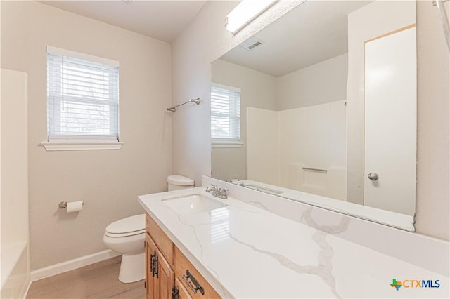 bathroom with baseboards, visible vents, toilet, wood finished floors, and vanity