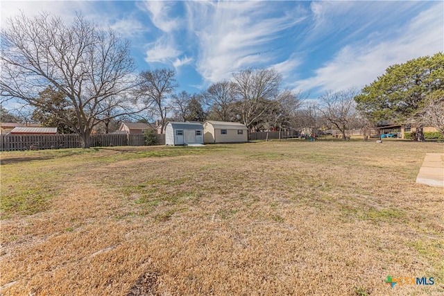 view of yard featuring fence and an outdoor structure