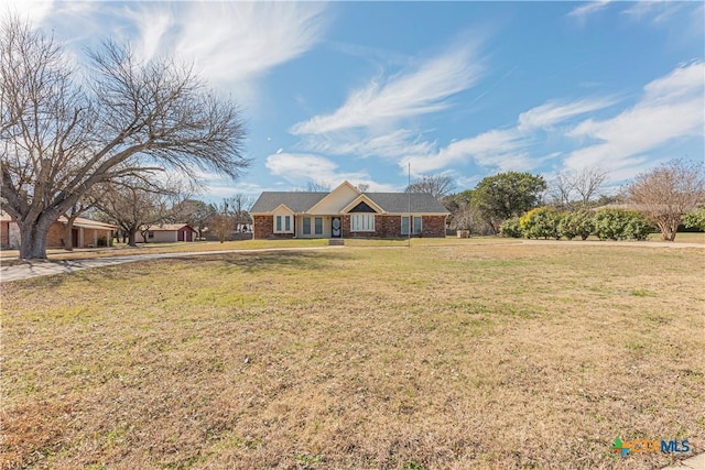 ranch-style house featuring a front lawn and brick siding