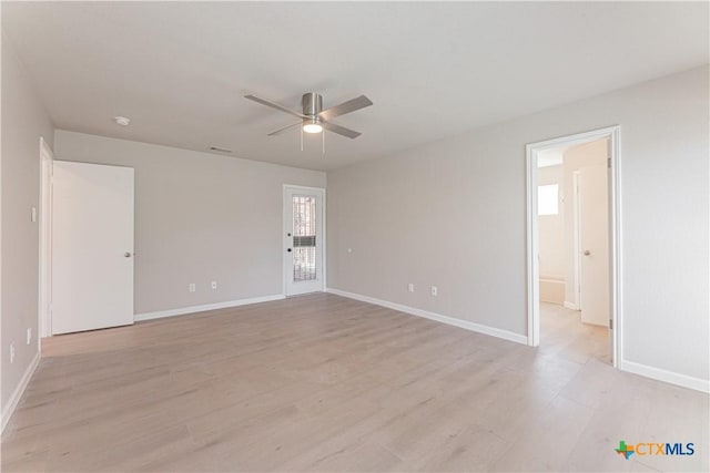 spare room with light wood-type flooring, ceiling fan, and baseboards